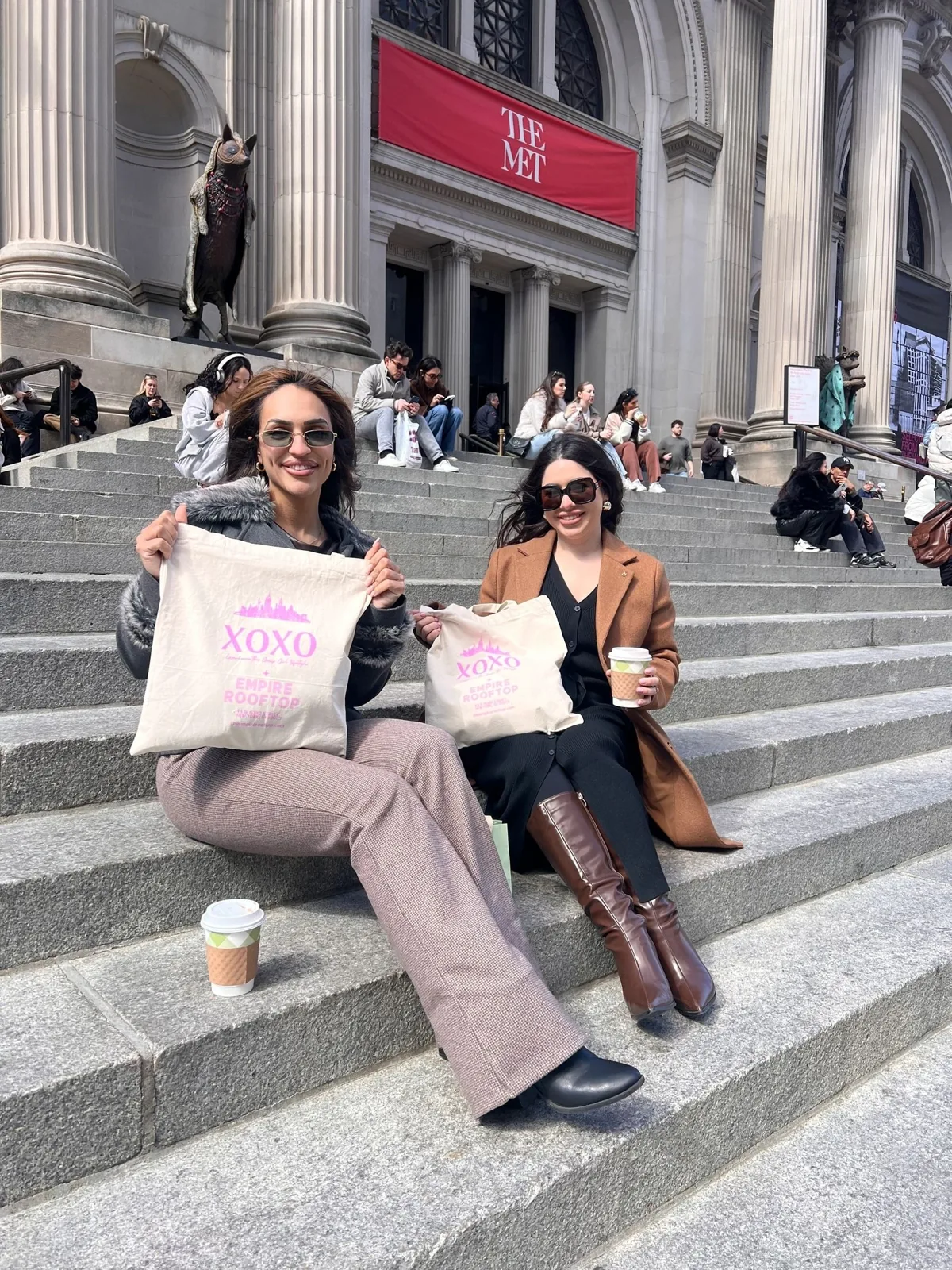Guests with XOXO tote bags on the Met steps